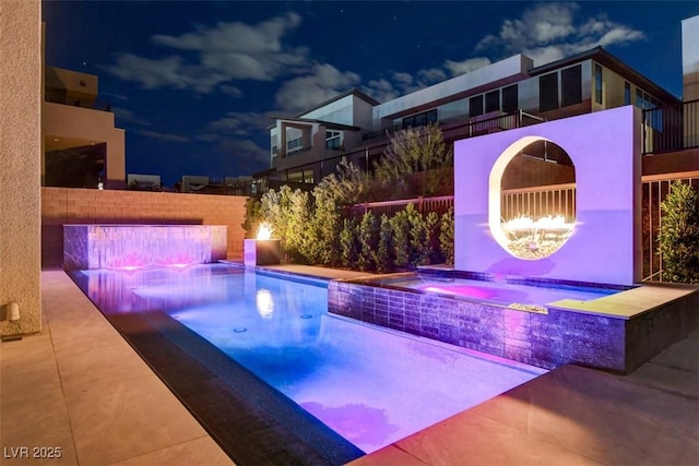 exterior space featuring fence, a fenced in pool, and an in ground hot tub