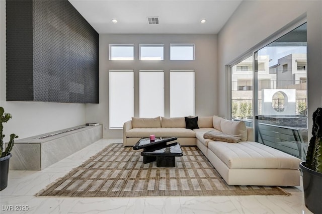 living room featuring marble finish floor, visible vents, and recessed lighting