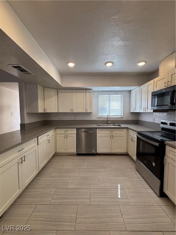 kitchen with white cabinetry, sink, a textured ceiling, and appliances with stainless steel finishes