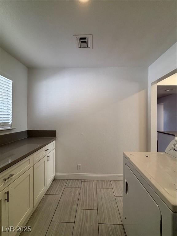 washroom featuring cabinets and washer / dryer