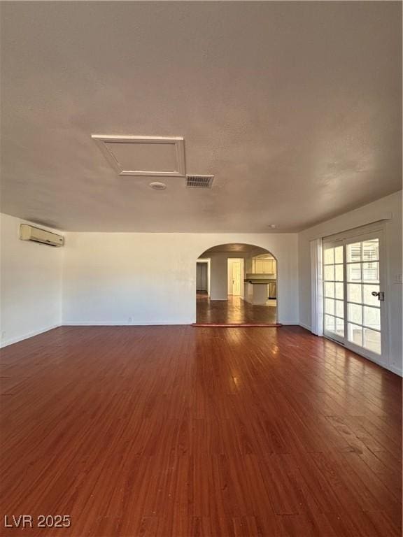 unfurnished room featuring dark wood-type flooring and a wall mounted AC