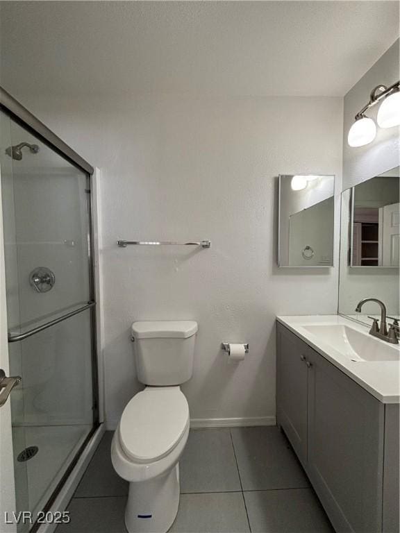 bathroom with vanity, tile patterned floors, toilet, and walk in shower