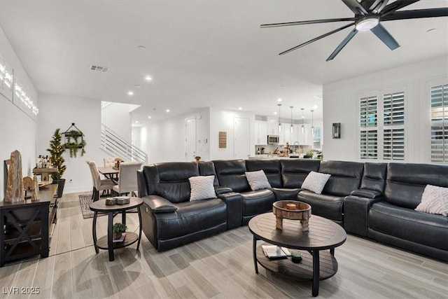 living room with a healthy amount of sunlight, light hardwood / wood-style flooring, and ceiling fan