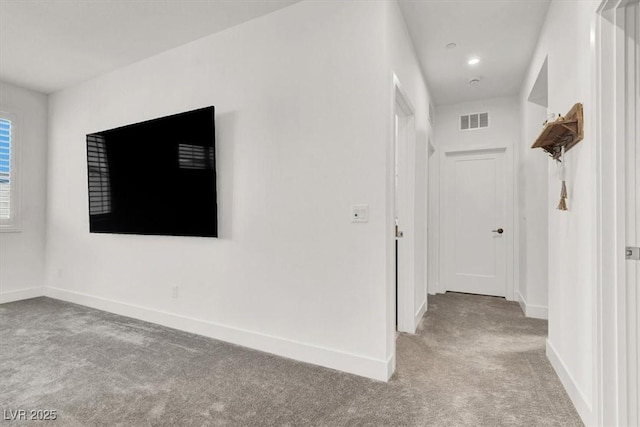 hallway featuring light colored carpet