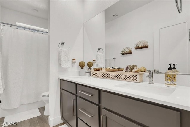 full bathroom with vanity, shower / bath combo, and toilet