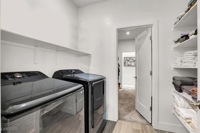 laundry room with light hardwood / wood-style flooring and washing machine and dryer