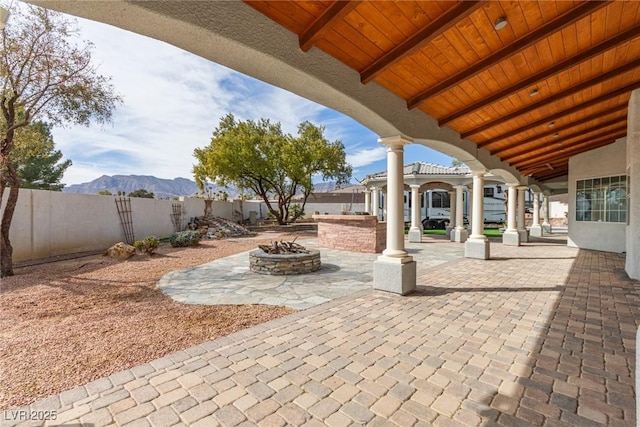 view of patio with a mountain view and an outdoor fire pit