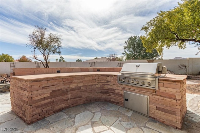 view of patio featuring a grill and an outdoor kitchen