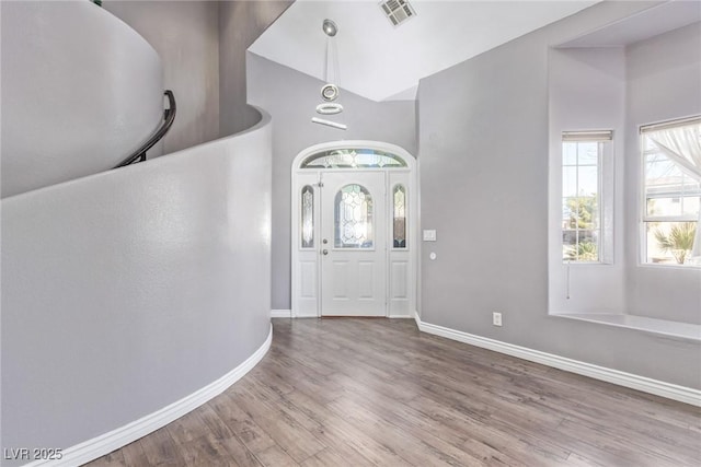 foyer with hardwood / wood-style floors and vaulted ceiling