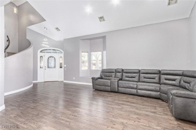 unfurnished living room featuring wood-type flooring and vaulted ceiling