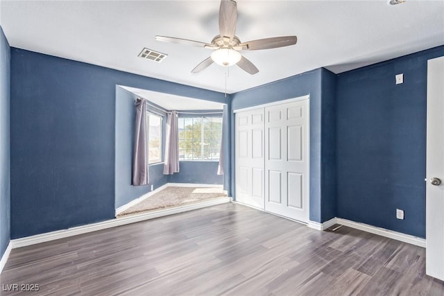 unfurnished bedroom with hardwood / wood-style flooring, ceiling fan, and a closet