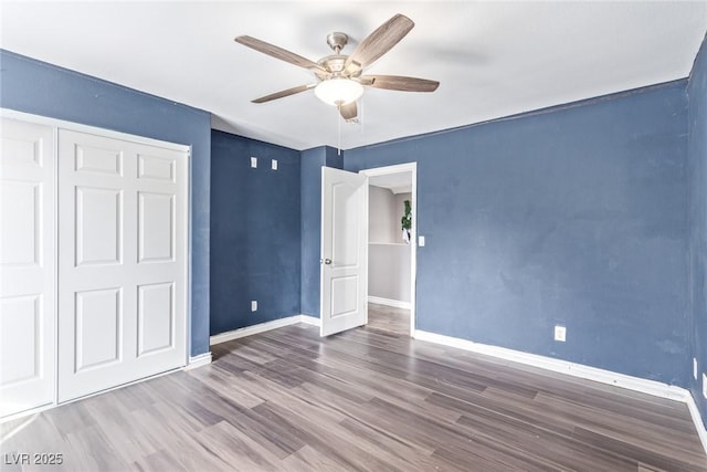 unfurnished bedroom with wood-type flooring, ceiling fan, and a closet