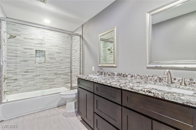 full bathroom with vanity, shower / bath combination with glass door, and toilet