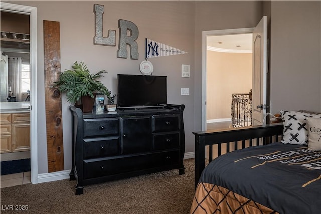 carpeted bedroom with crown molding and ensuite bath