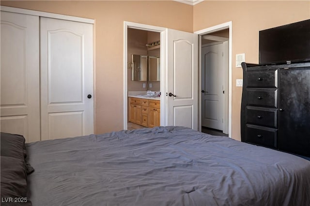 bedroom featuring connected bathroom, sink, and a closet