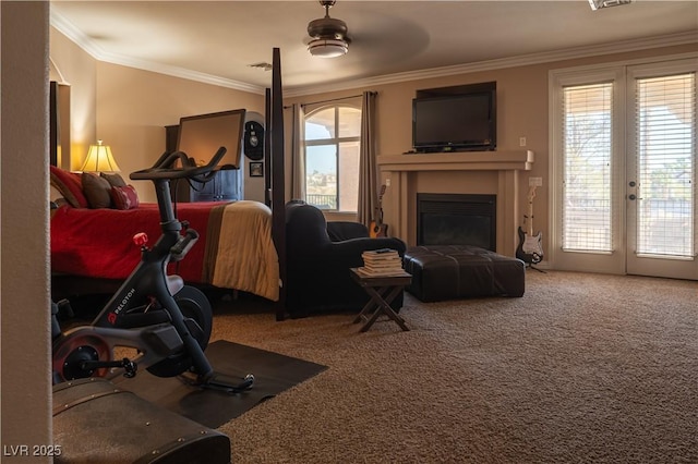 exercise area featuring crown molding, ceiling fan, a healthy amount of sunlight, and carpet flooring