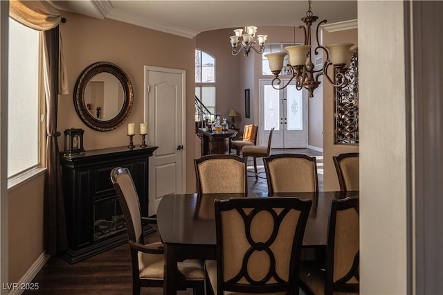 dining space featuring an inviting chandelier, ornamental molding, and dark hardwood / wood-style floors