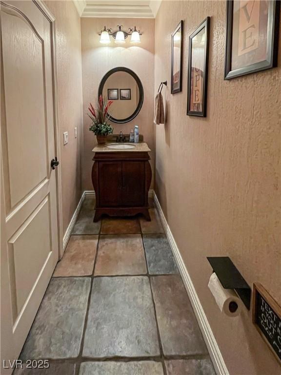 bathroom with ornamental molding and vanity