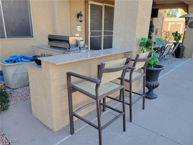 view of patio / terrace with area for grilling and an outdoor bar