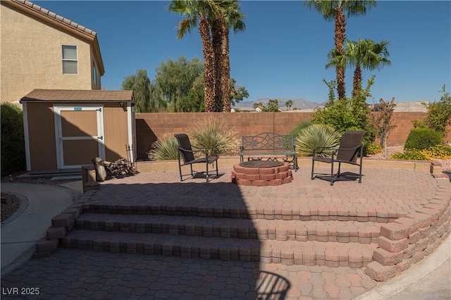 view of patio featuring an outdoor fire pit and a storage unit