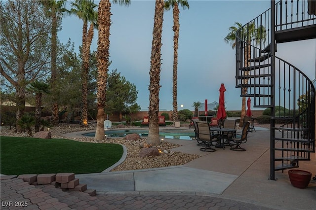 surrounding community featuring a lawn, a patio area, and a pool with hot tub