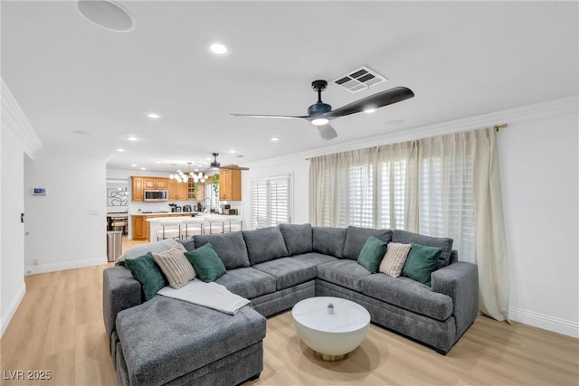 living room featuring ceiling fan, crown molding, and light hardwood / wood-style floors