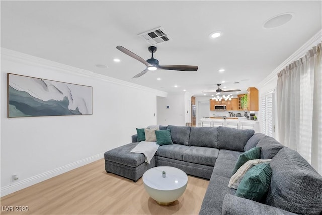 living room with light hardwood / wood-style floors, crown molding, and ceiling fan