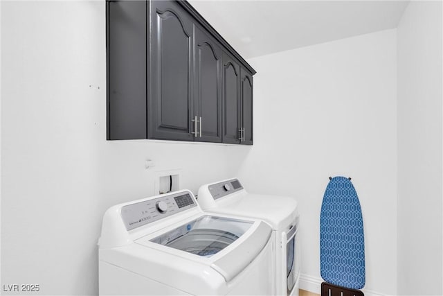 clothes washing area featuring cabinets and washing machine and dryer