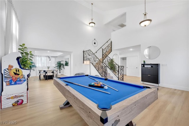 rec room with a high ceiling, pool table, and light hardwood / wood-style floors