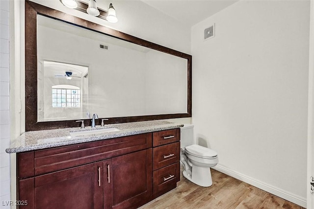 bathroom with hardwood / wood-style flooring, vanity, and toilet