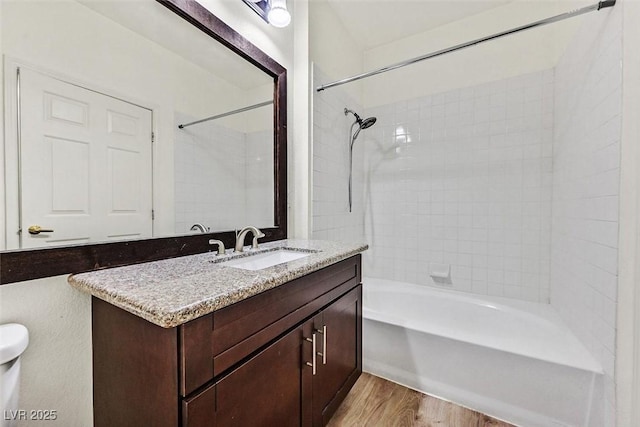 bathroom featuring vanity, hardwood / wood-style floors, and tiled shower / bath