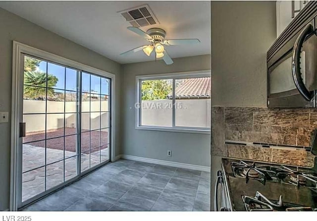 kitchen featuring backsplash, gas range oven, and ceiling fan