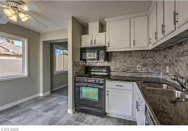 kitchen with dark stone countertops, sink, black appliances, and white cabinets