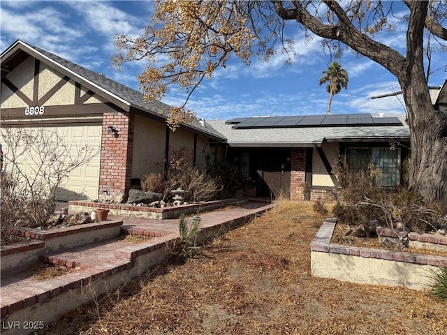 view of front of property with a garage and solar panels