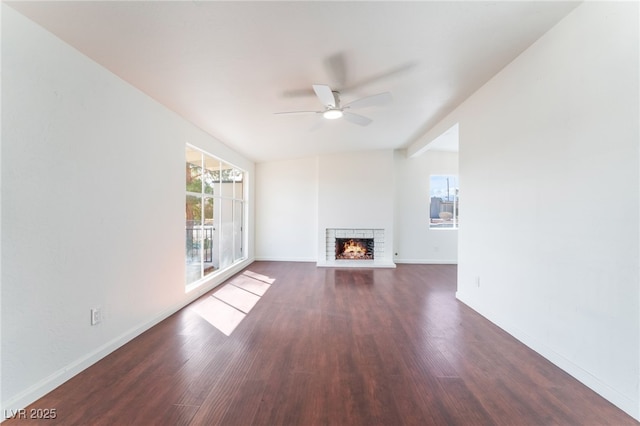 unfurnished living room with ceiling fan, dark hardwood / wood-style flooring, vaulted ceiling, and a brick fireplace