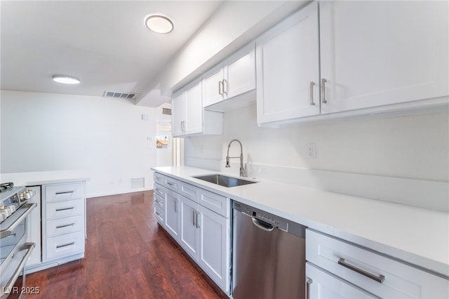 kitchen with sink, stainless steel appliances, dark hardwood / wood-style floors, and white cabinets