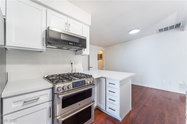 kitchen featuring stainless steel appliances, dark wood-type flooring, white cabinets, and kitchen peninsula