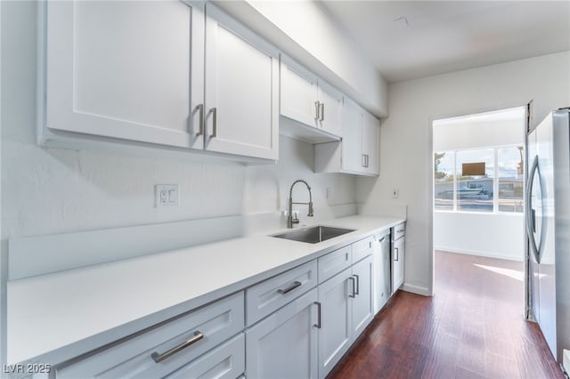 kitchen featuring dark wood-type flooring, appliances with stainless steel finishes, sink, and white cabinets