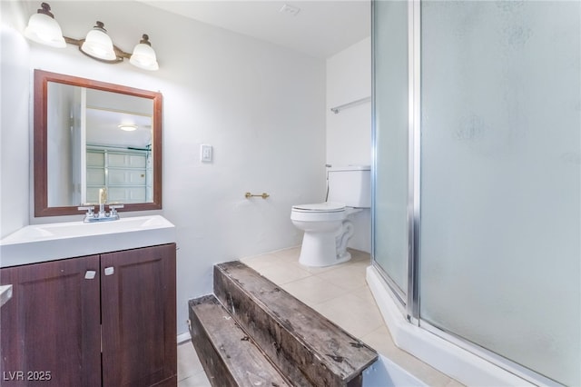 bathroom with vanity, toilet, tile patterned floors, and a shower with shower door