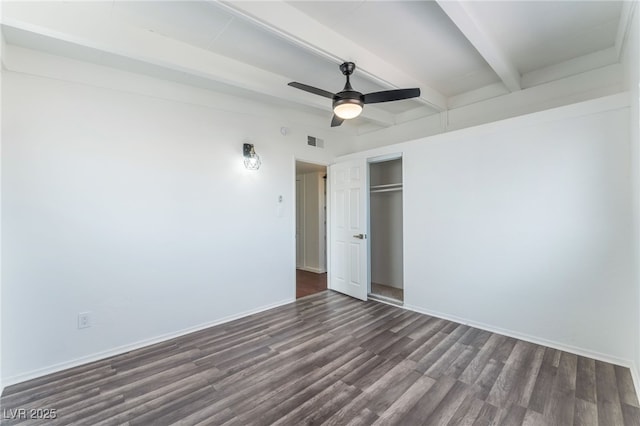 unfurnished bedroom featuring dark wood-type flooring, ceiling fan, beam ceiling, and a closet