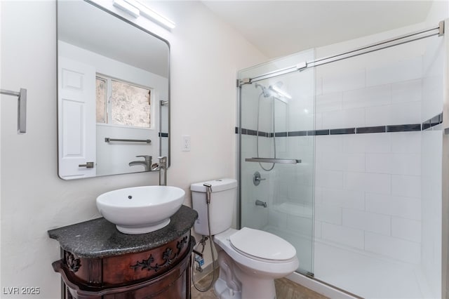 bathroom featuring vanity, toilet, and a shower with door