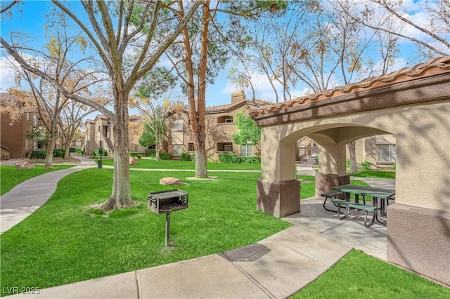 view of community featuring a patio and a lawn