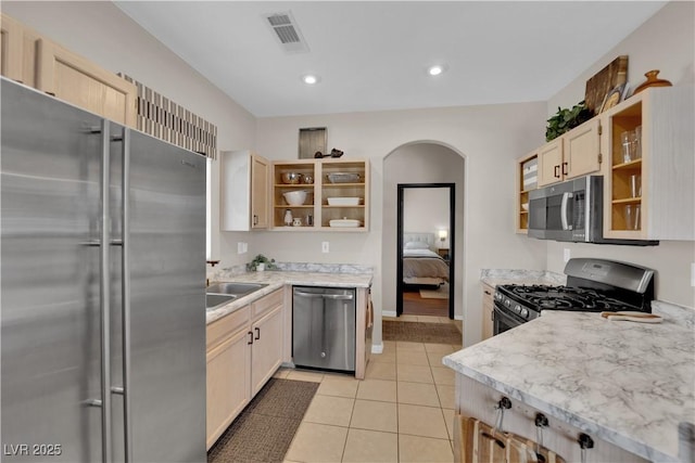 kitchen featuring light brown cabinetry, sink, stainless steel appliances, and light tile patterned flooring