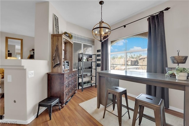 dining room featuring light hardwood / wood-style flooring and a notable chandelier