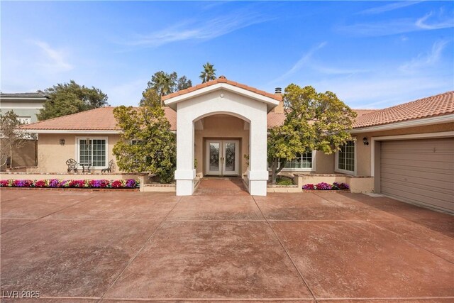 mediterranean / spanish-style home featuring french doors and a garage