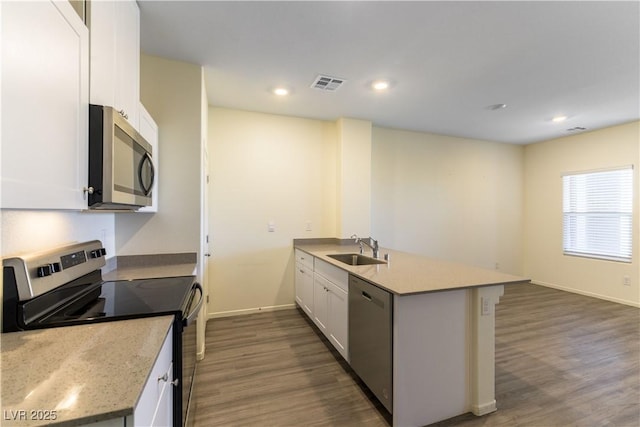 kitchen with dark wood-style flooring, a sink, visible vents, white cabinets, and appliances with stainless steel finishes