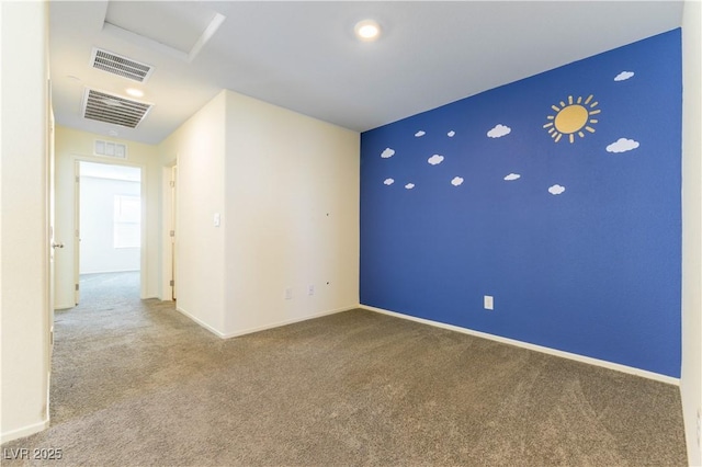 carpeted empty room featuring attic access, visible vents, and baseboards