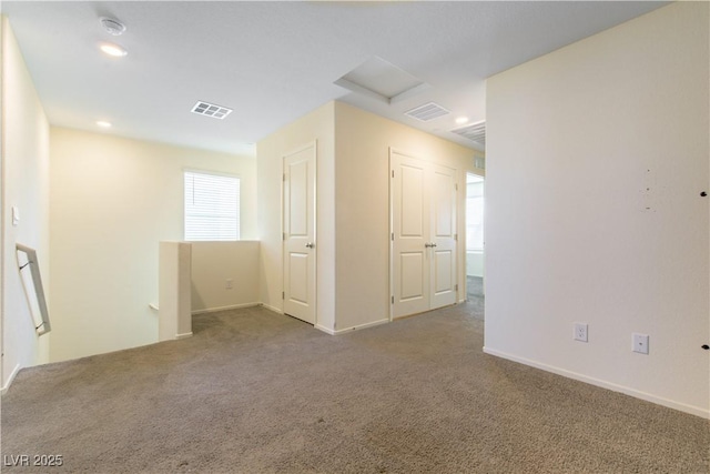 spare room with recessed lighting, carpet flooring, visible vents, baseboards, and attic access