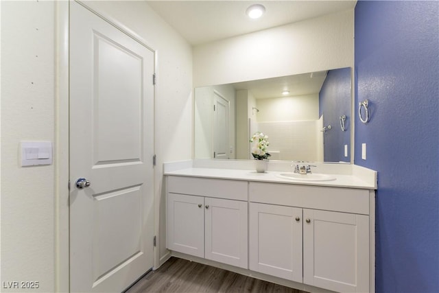 full bathroom featuring wood finished floors and vanity