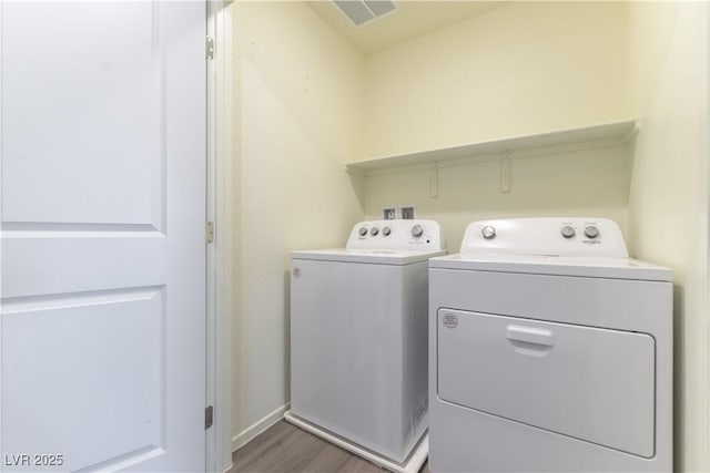 washroom featuring visible vents, wood finished floors, laundry area, independent washer and dryer, and baseboards